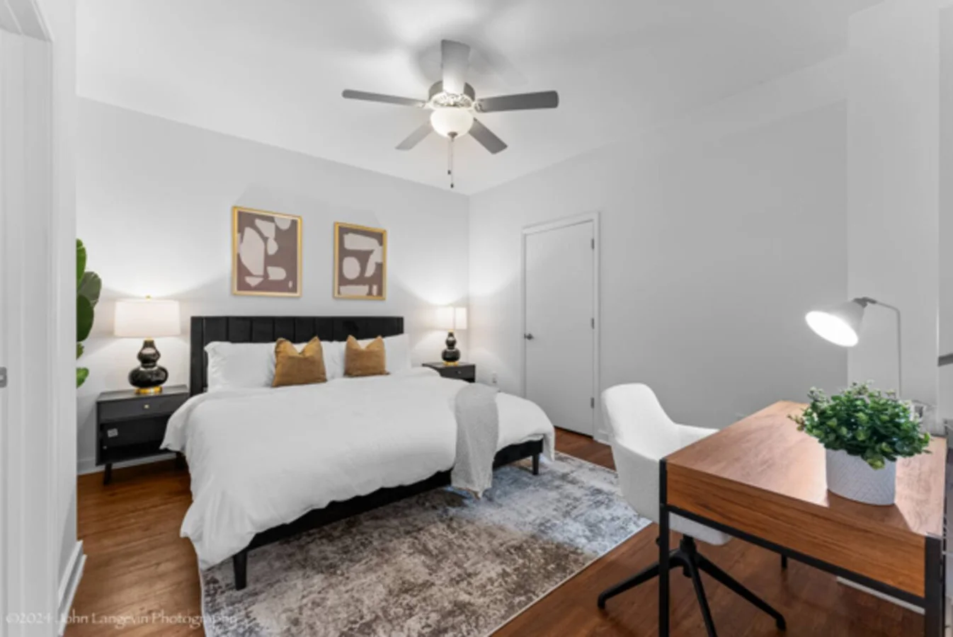 Retreat to the cozy master bedroom featuring a luxurious king-size bed with plush pillows, modern decor, blackout curtains, and a convenient workspace for all your needs.