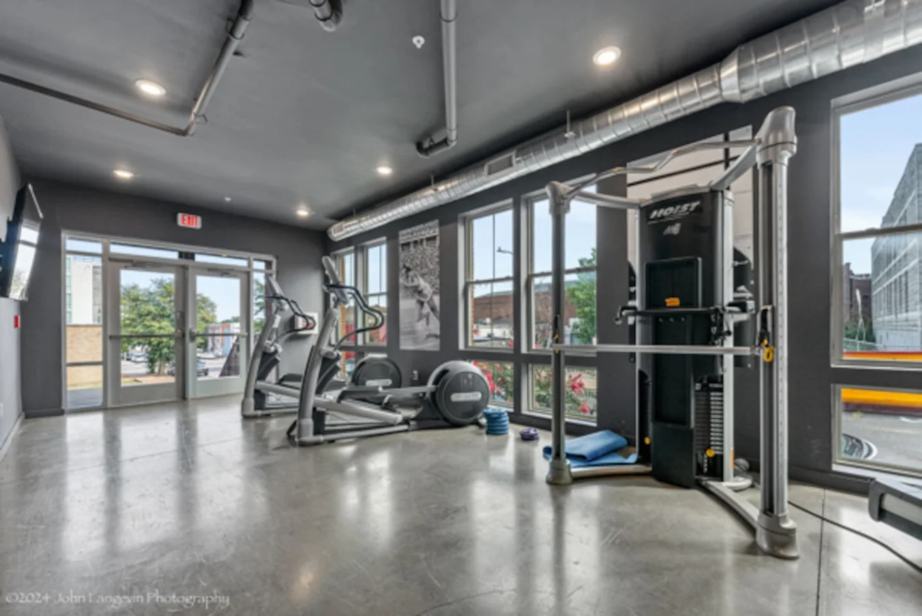 Spacious, well-lit gym equipped with a variety of cardio machines, free weights, and strength-training equipment.