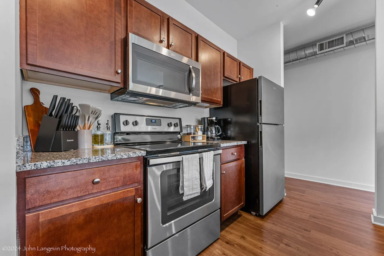 Cook with ease in this well-equipped kitchen featuring stainless steel appliances, ample cabinetry, and a stylish backsplash. Whether you're brewing coffee or preparing a gourmet meal, this space is designed for functionality and style, making every meal