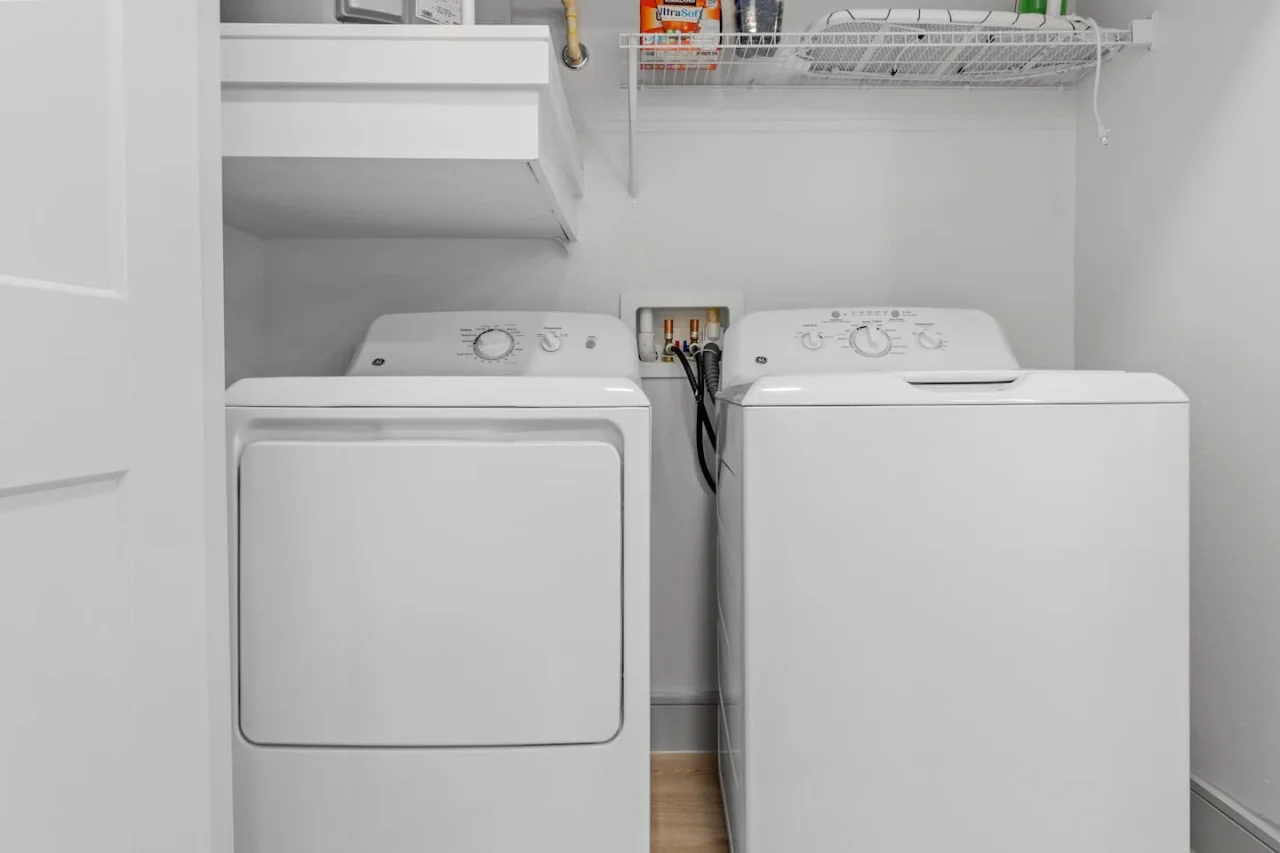 As you step into the laundry room, the modern appliances and ample storage space make it easy to keep things tidy.