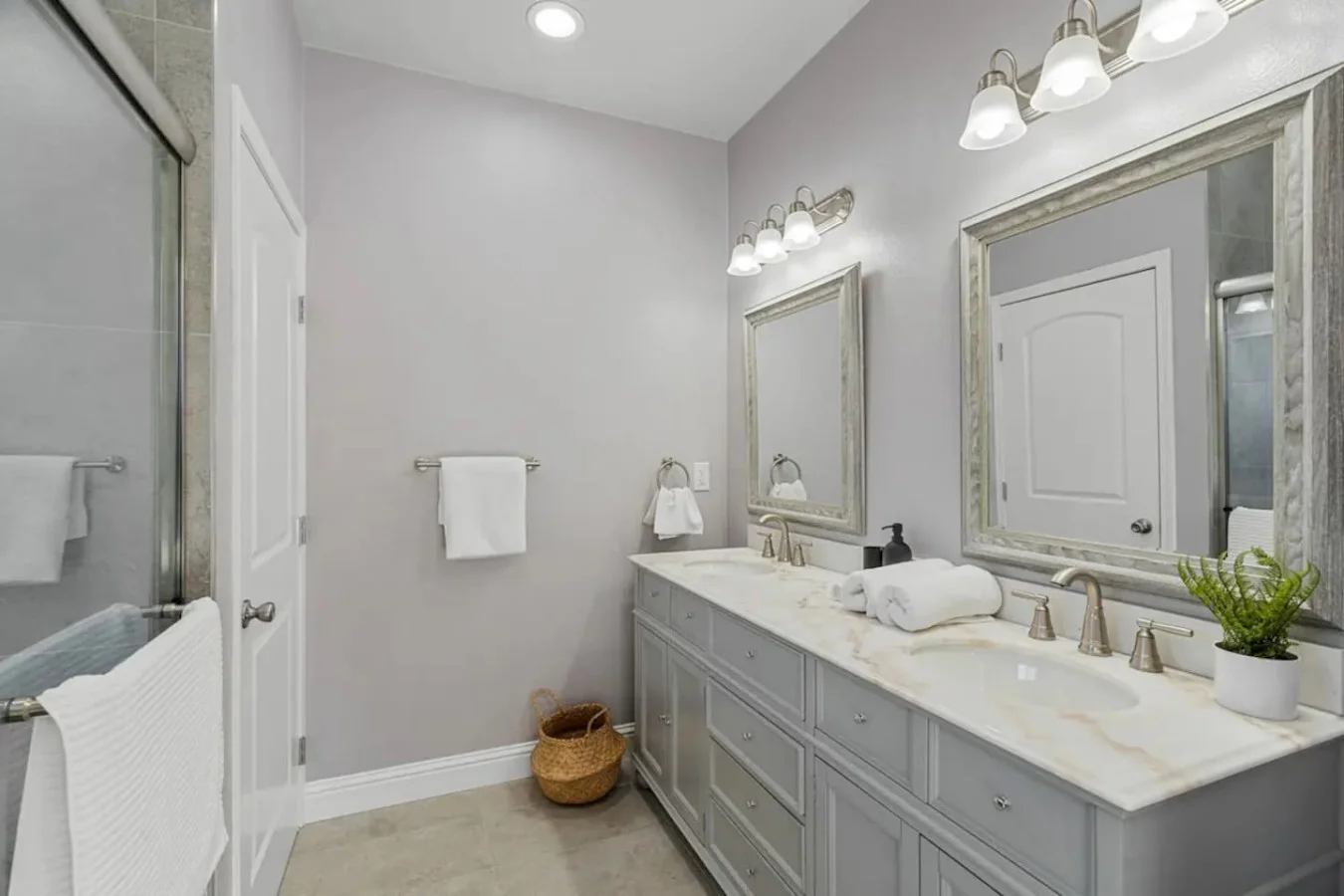 This bright and welcoming bathroom invites you to freshen up in comfort. Enjoy the forest-inspired shower curtain that adds a calming touch to your routine, complemented by the cozy rug underfoot and sparkling clean fixtures.