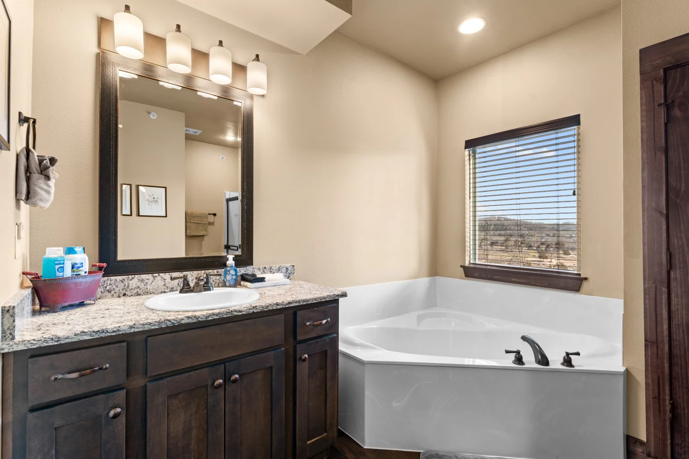 This main-floor bathroom offers a separate soaking tub and a walk-in shower, with the added convenience of a private ensuite entrance and a separate door for guest access