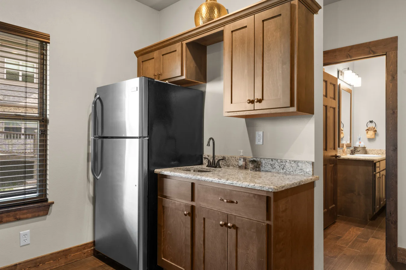 Convenient game room kitchenette featuring a full-size fridge for easy refreshments.