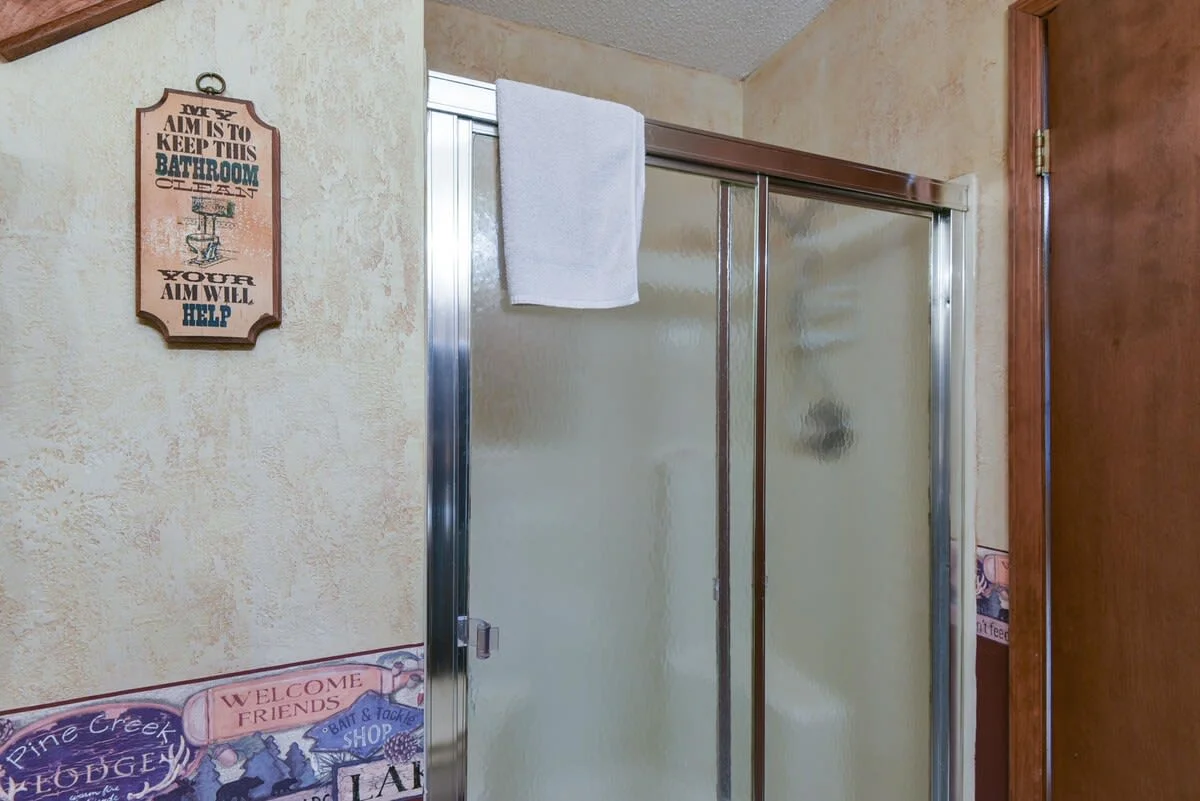 Main bathroom with step in shower with small built in seat.