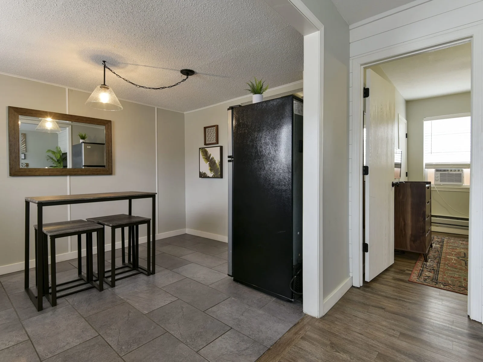 Living room with a view of the kitchen and entrance to the bedroom.