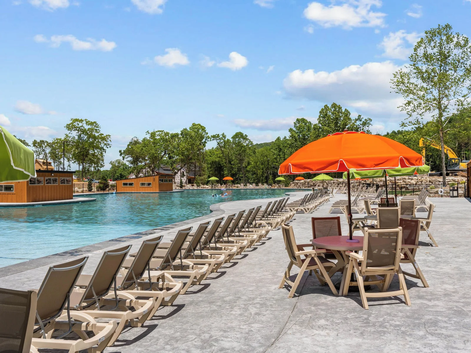 Outdoor pool seating available including table and chairs with umbrella.