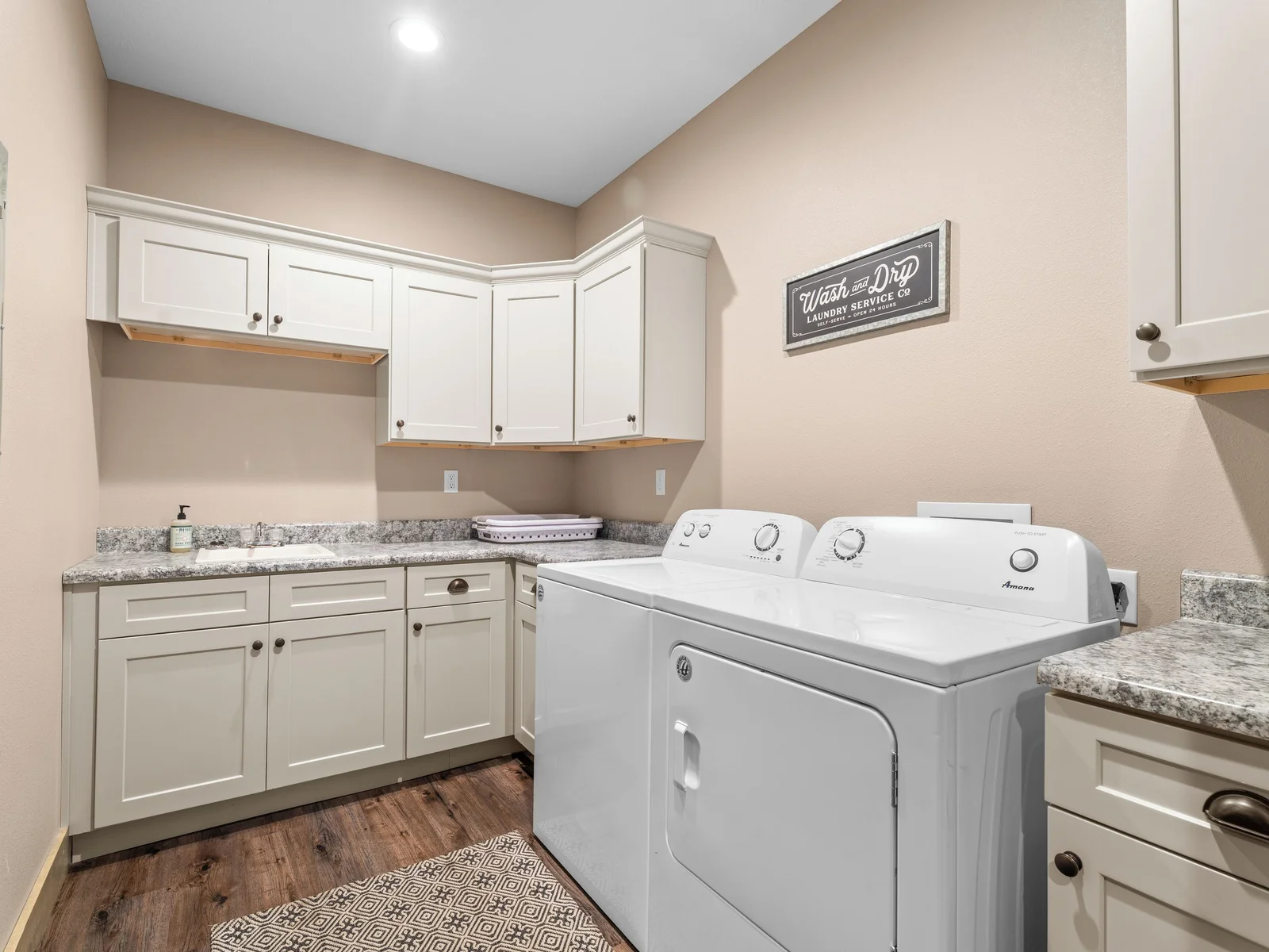 Main level laundry room. Full-size machines. Ironing station, clothes rack, and small sink for delicates. There's another laundry room on the lower level.