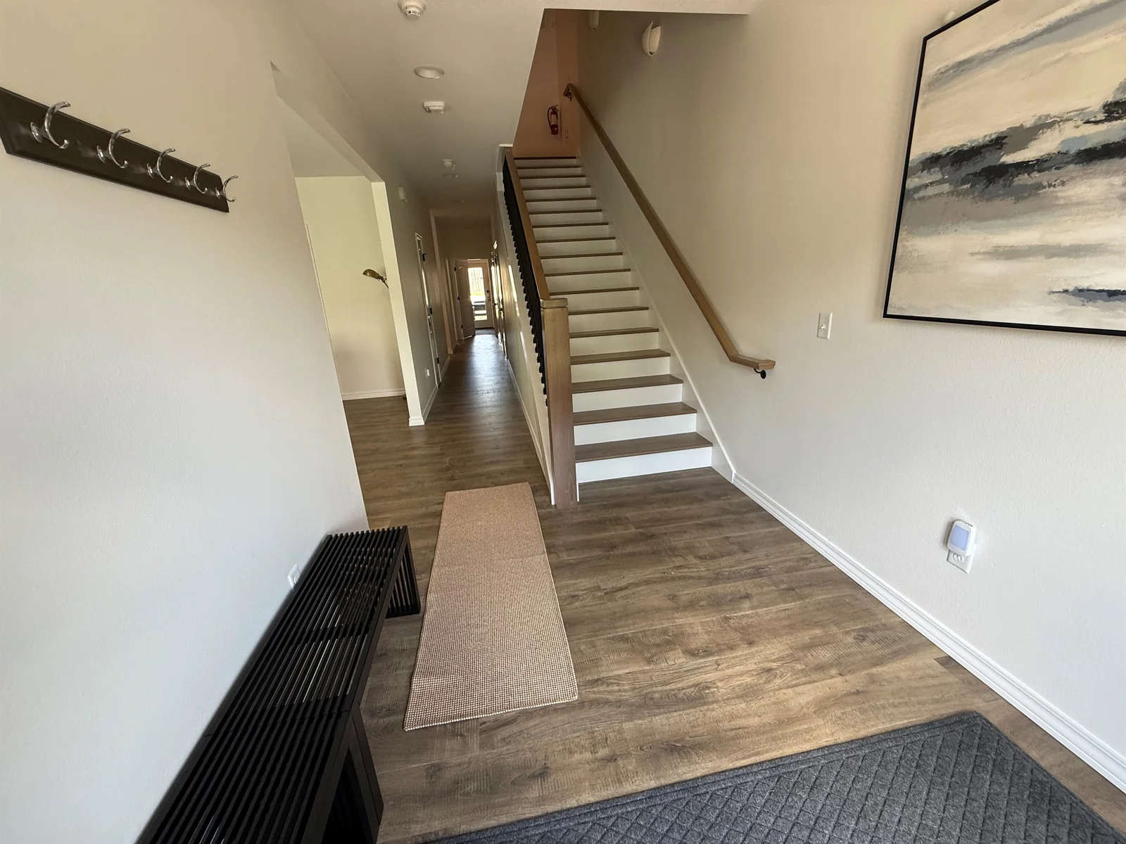 Hallway. Stairs to second floor. Hand stained steps and railings.