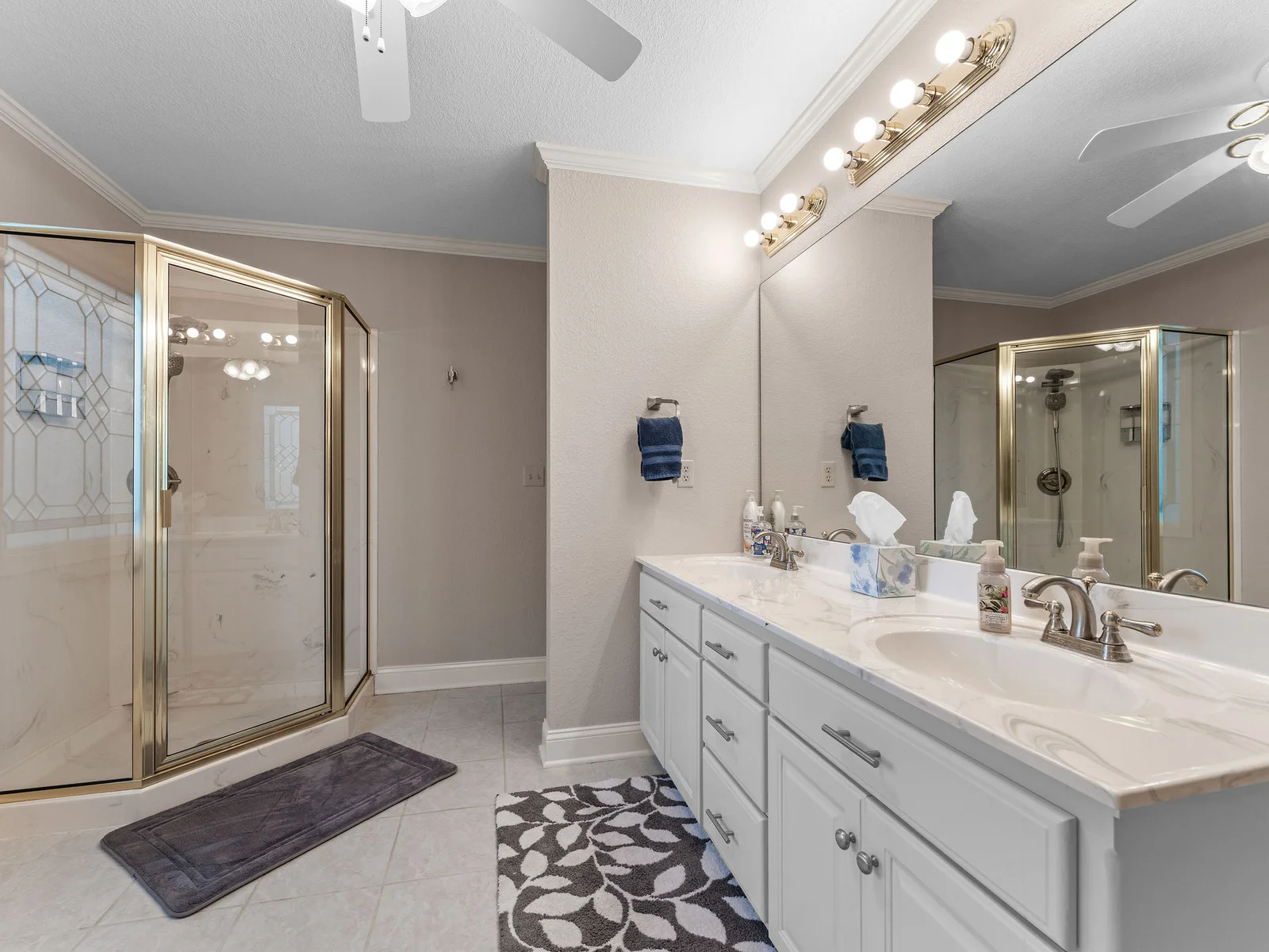 Double vanity, walk-in glass shower, and warm tile underfoot — the primary en-suite has everything you need for a long morning without sharing a sink.