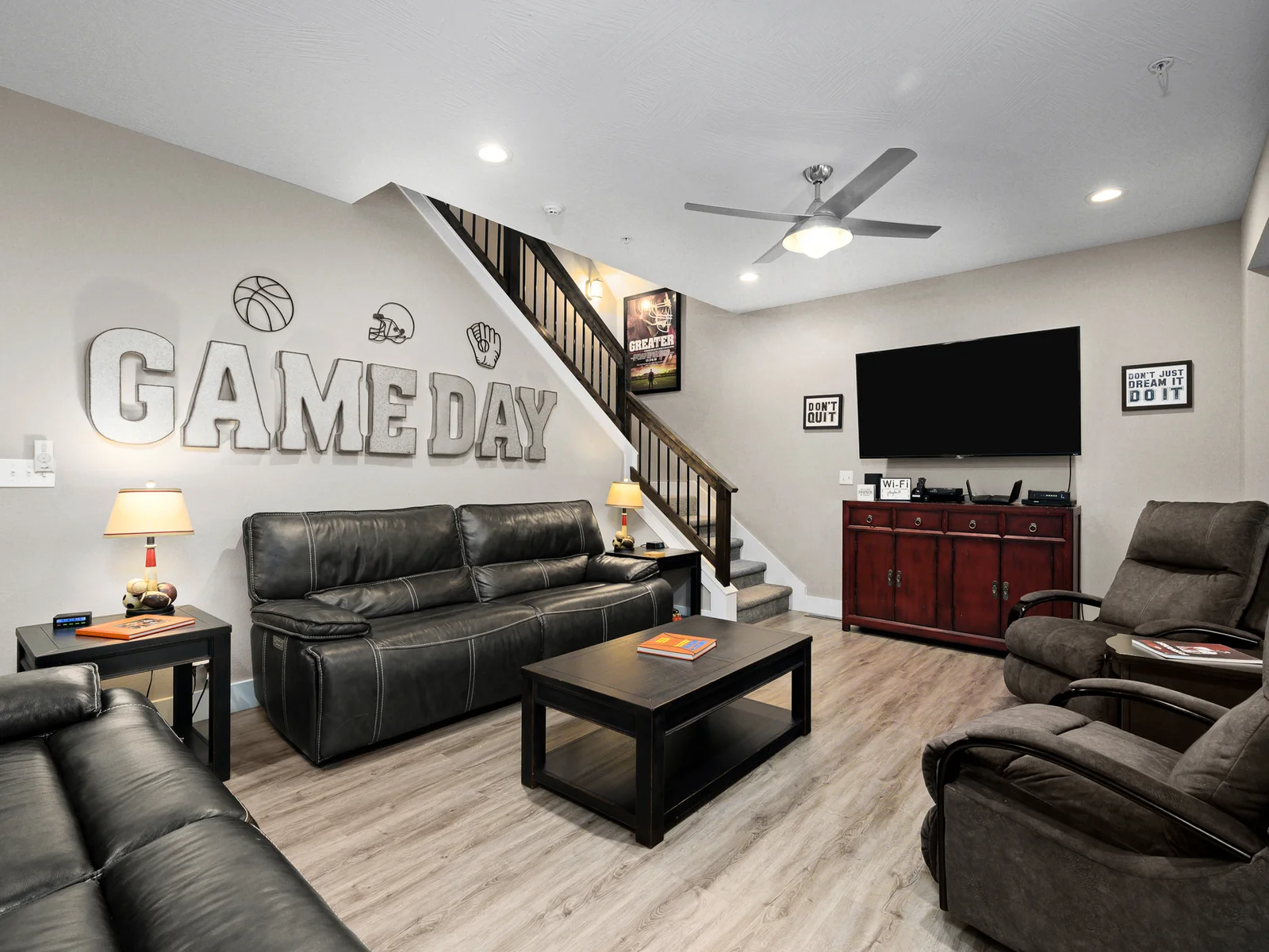 Main level living area with 65" TV, electric fireplace, and fully reclining leather chairs