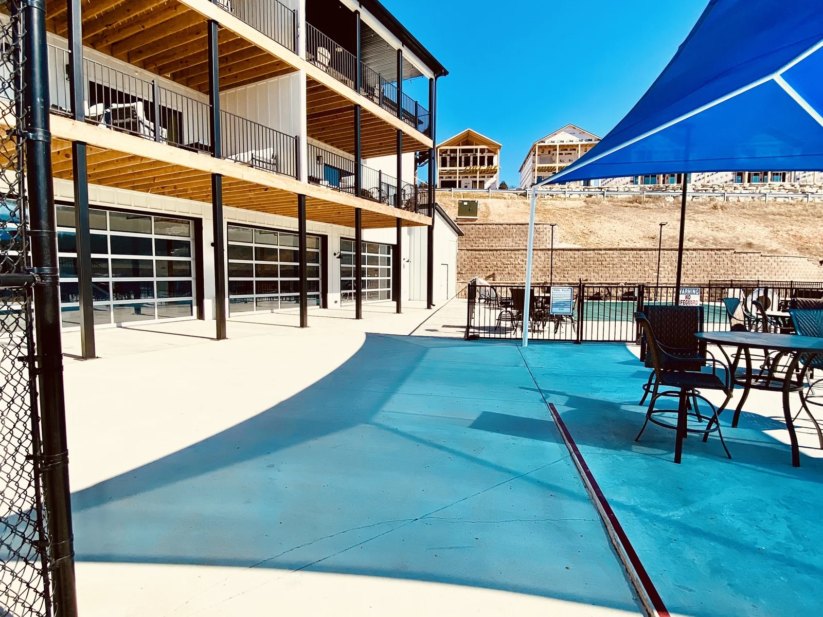 Indoor pool is right beside the larger outdoor pool and the playground just inside these garage doors.