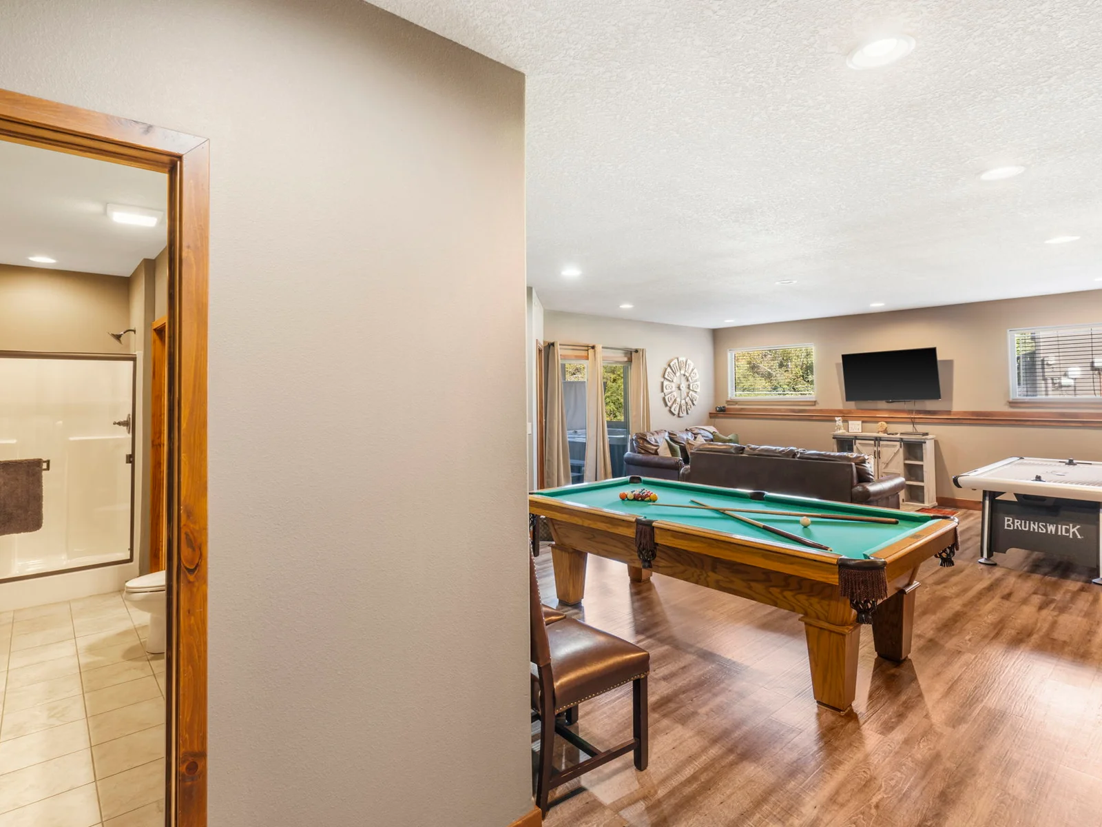 Lower level game room with airhockey, arcade game, and PS4