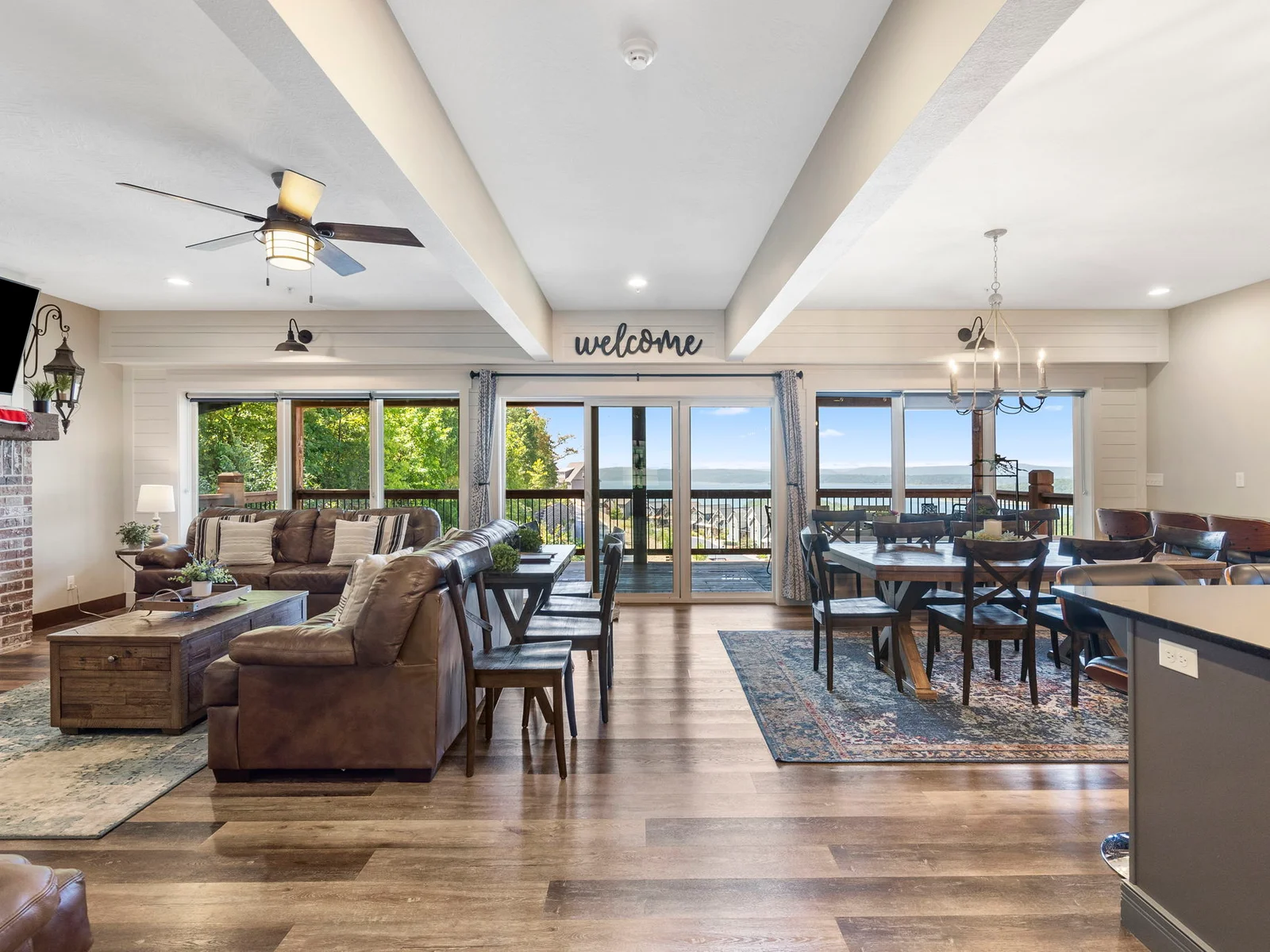 Main level living room with large TV and fireplace. Open dining and kitchen area.