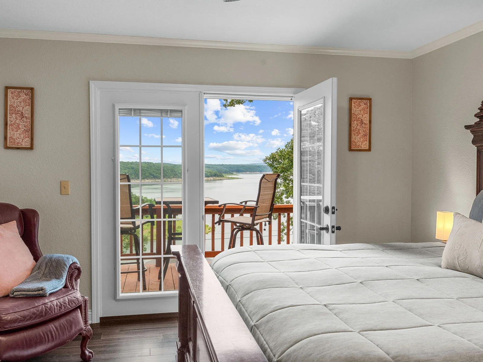 Wake up, push open the French doors, and the lake is right there. The primary bedroom opens directly to the private deck and the view — this is the room you book for.