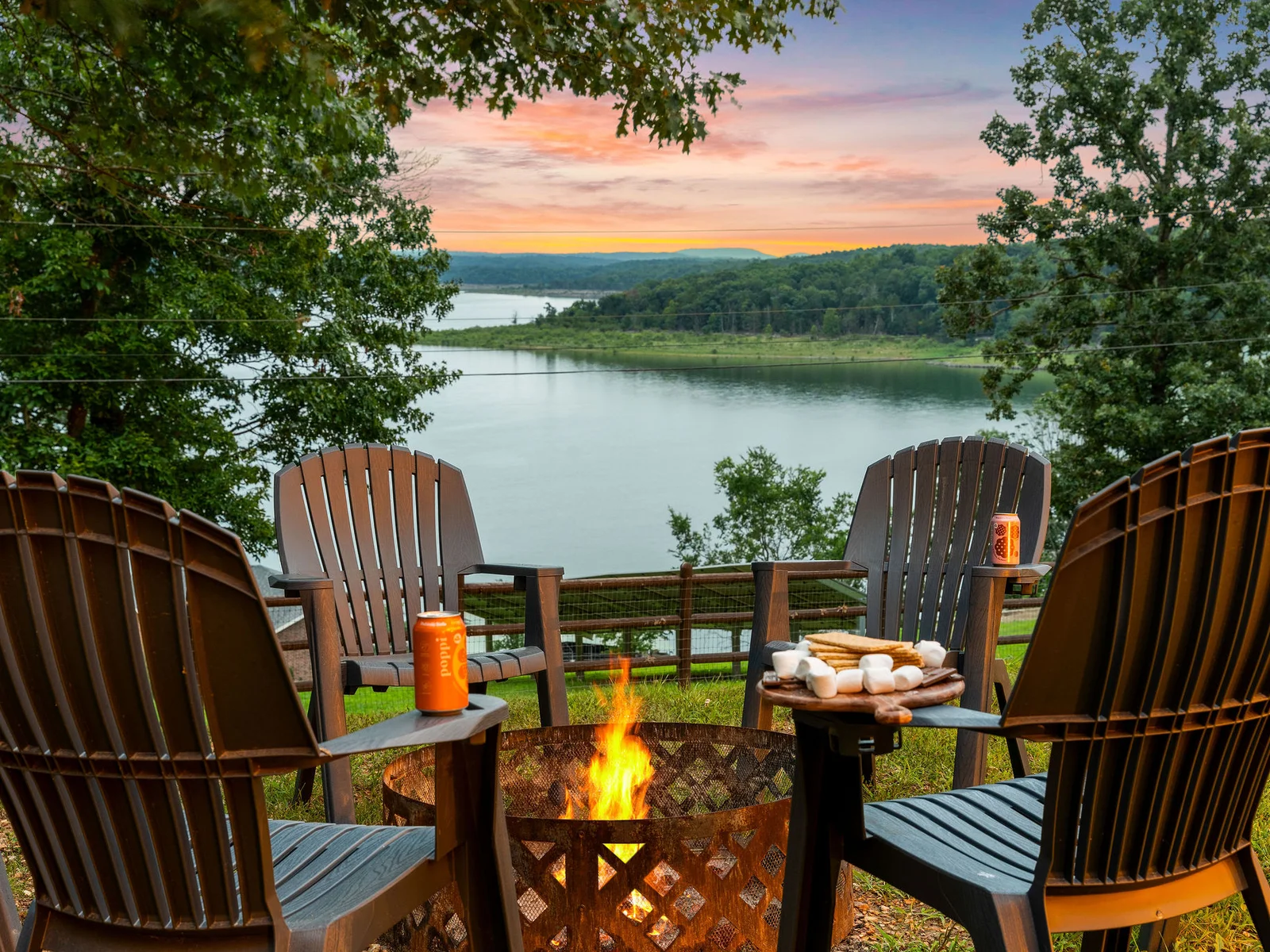 Pull an Adirondack up to the fire and load the s'mores board as the sky goes pink behind the lake — this is the fire pit at golden hour. Nothing beats it.