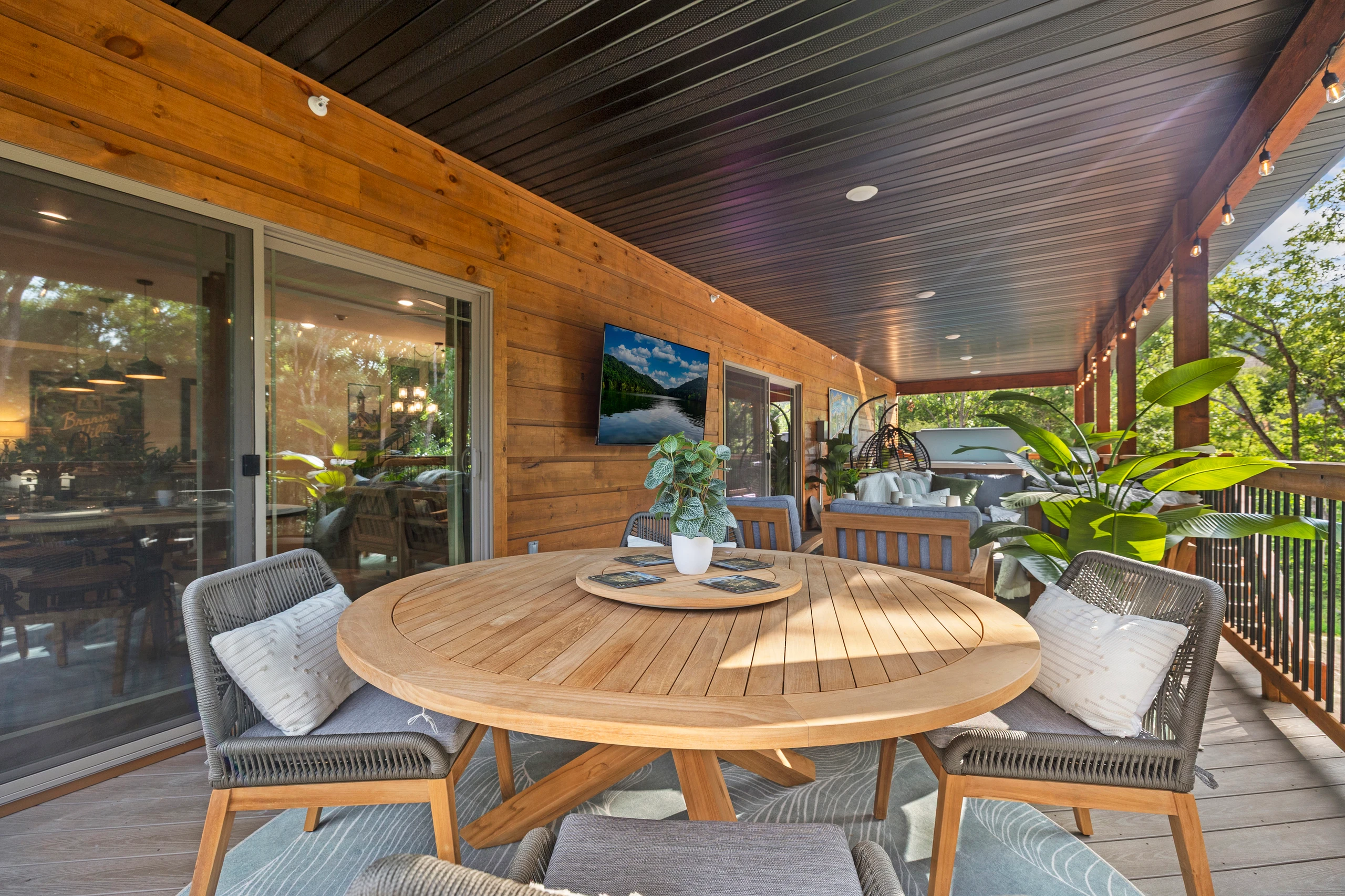 A round teak table for open-air meals under the covered deck.