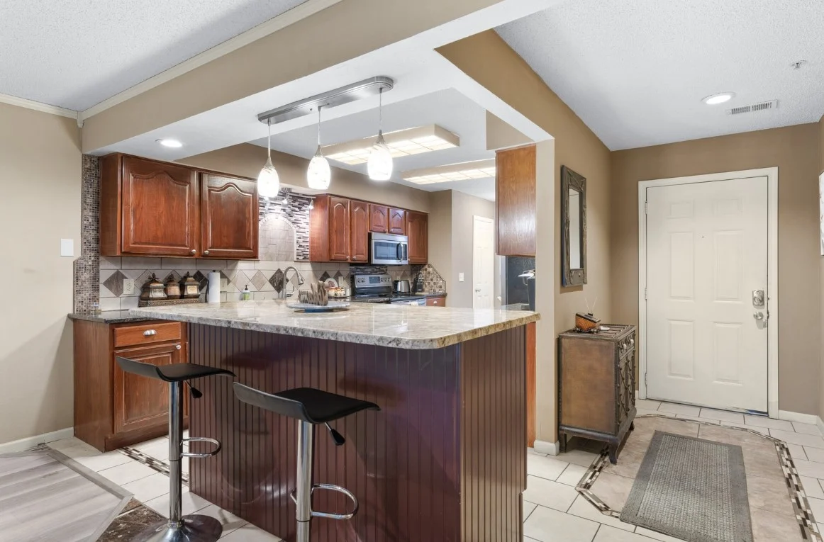 Spacious kitchen with bar seating and bright open layout.