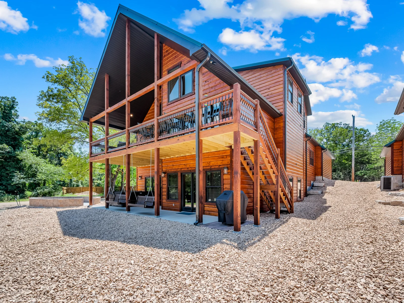 Back view. Firepit, private hot tub, propane grill, and swings will make this your dream vacation spot