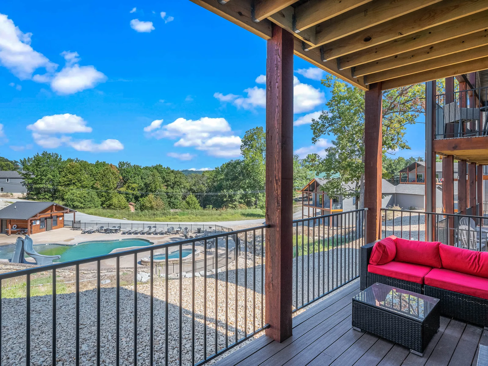 Upper deck with dining seating and outdoor couches provides a perfect vantage point for observing the community pool and hot tub