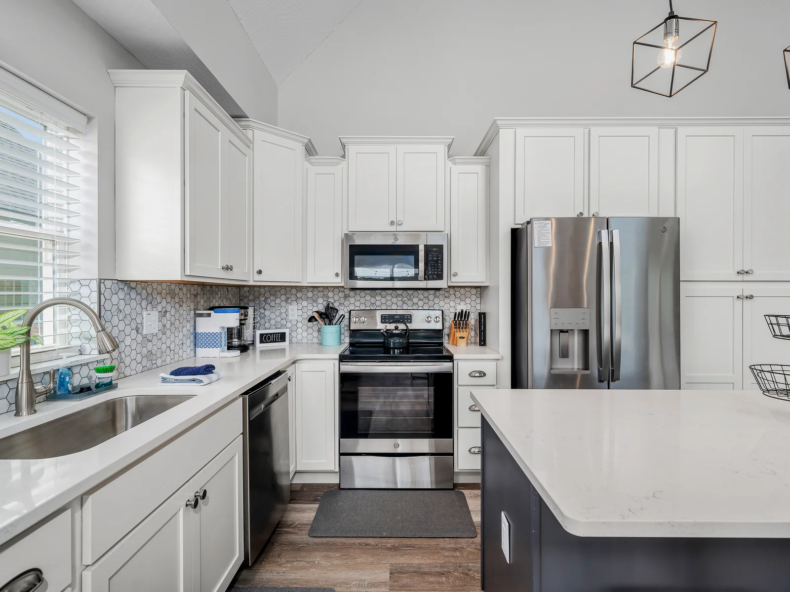 Clean white cabinetry perfectly offsets the stainless appliances and granite counters