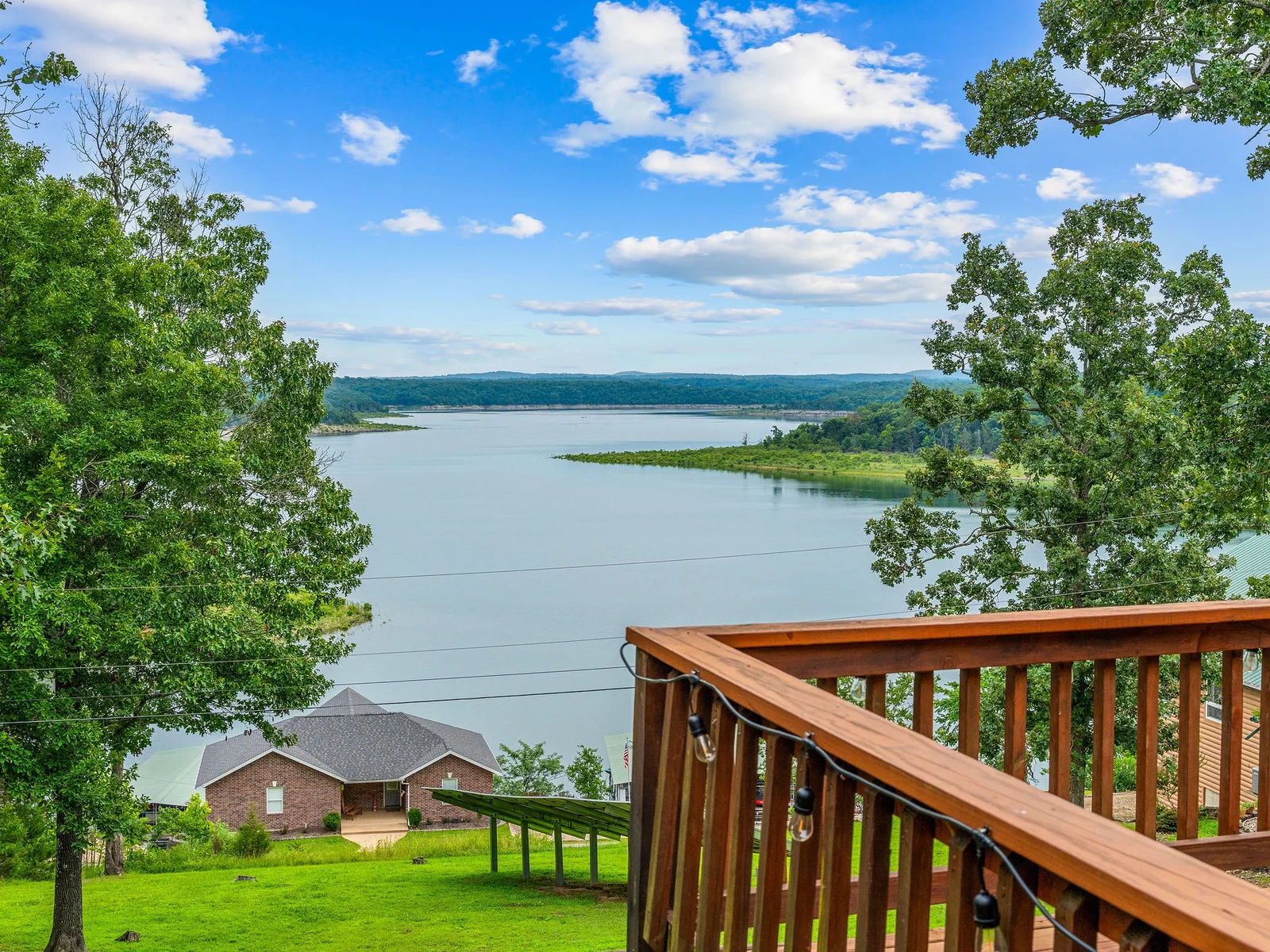 Step up to the deck railing and you have got an unobstructed frame of Bull Shoals Lake through the Ozark tree line. This view is there every morning with your coffee.