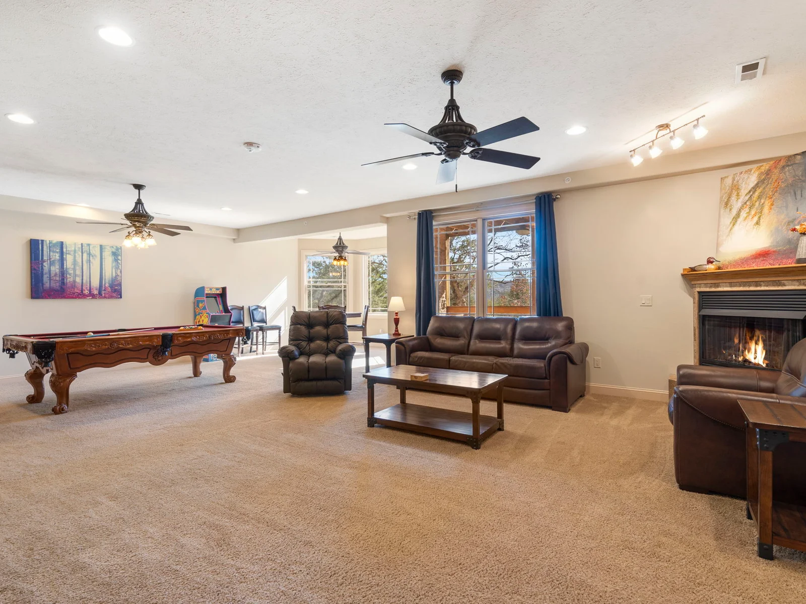 Lower level living and gaming space with electric fireplace, pool table, arcade games and more