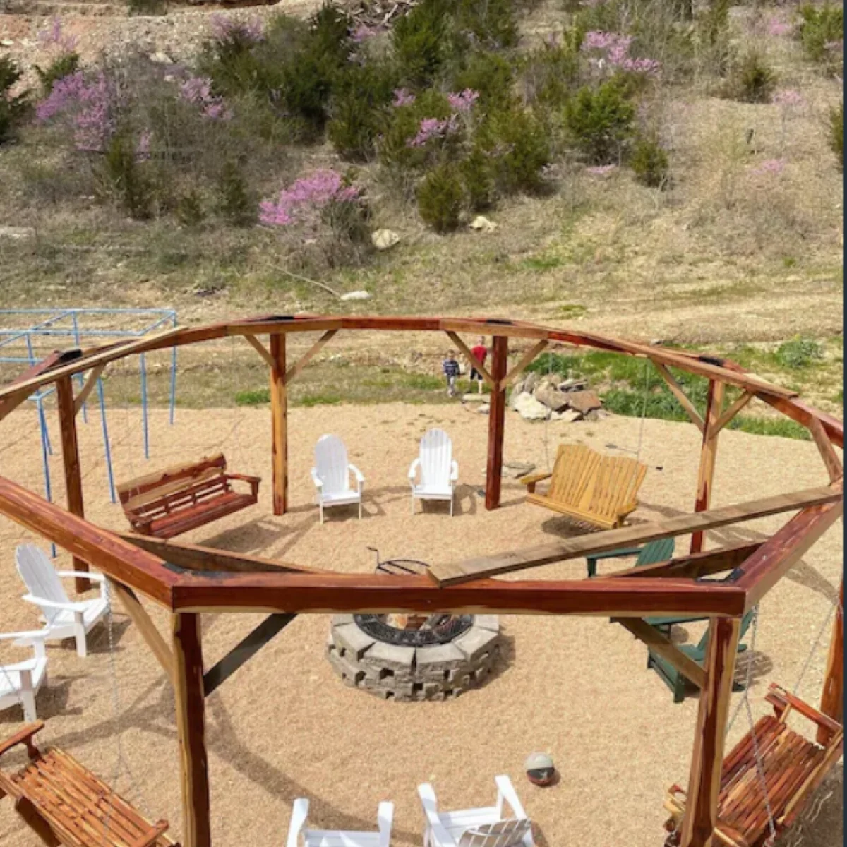 Octagonal swing structure surrounding the wood firepit is a unique space we know your group will love!