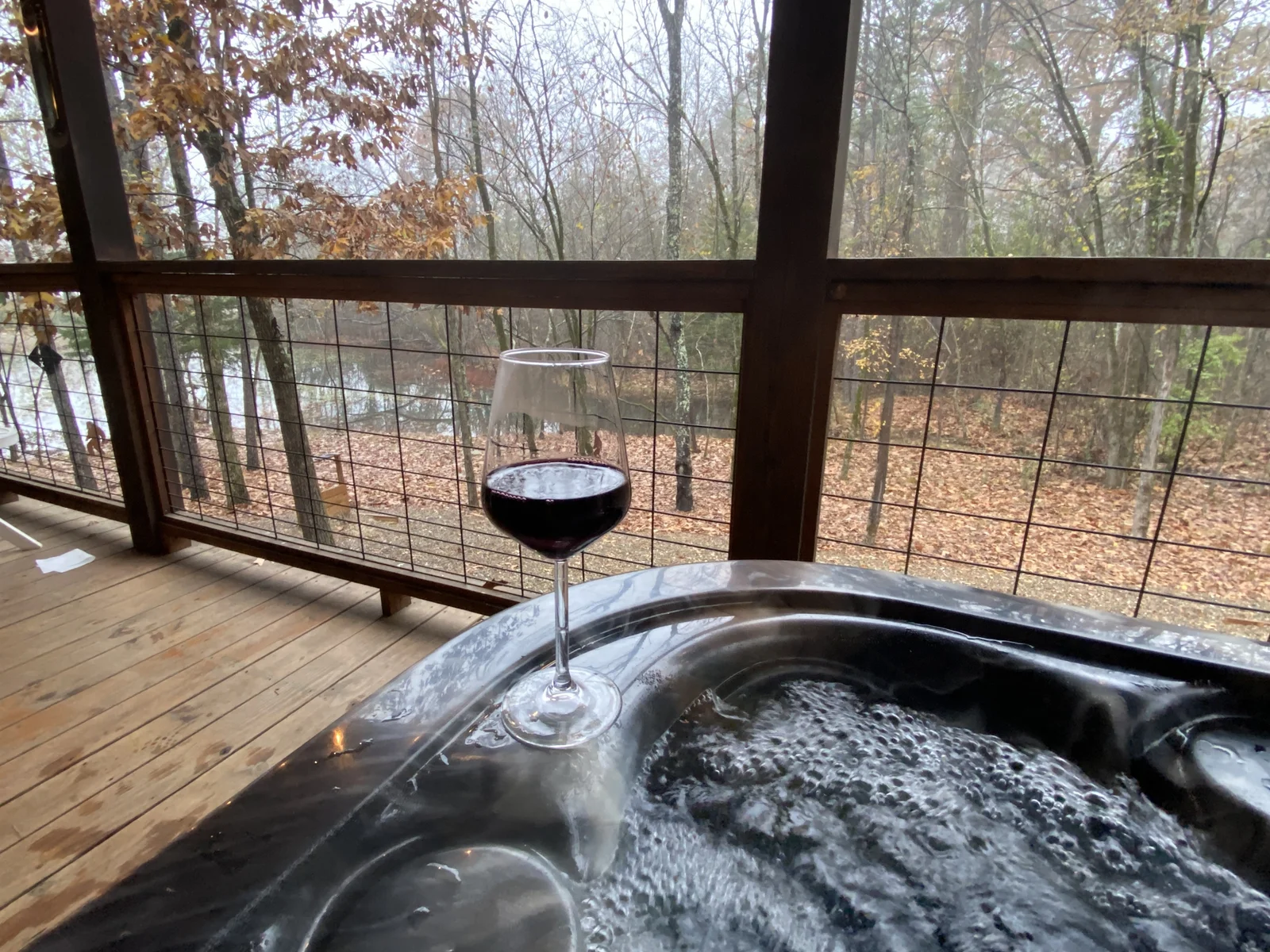 In the heart of nature, find serenity with wine, a hot tub, and a tranquil deck view. Here’s to peaceful escapes. 🍷🌲✨