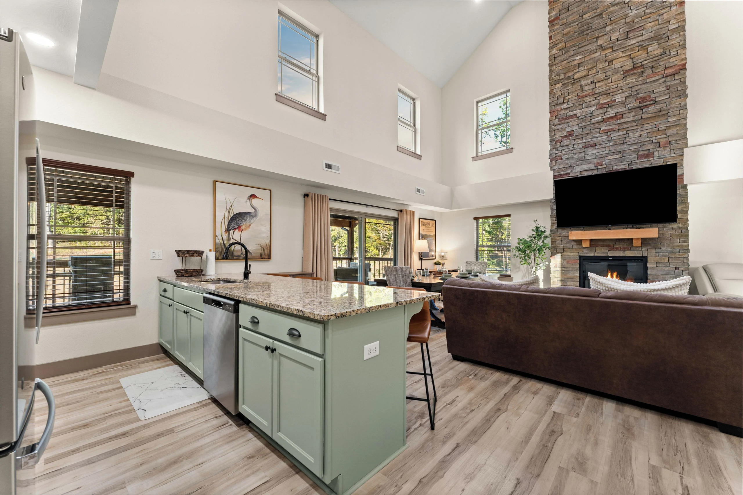 Kitchen with counter for seating 4 at barstools, large living room tv.