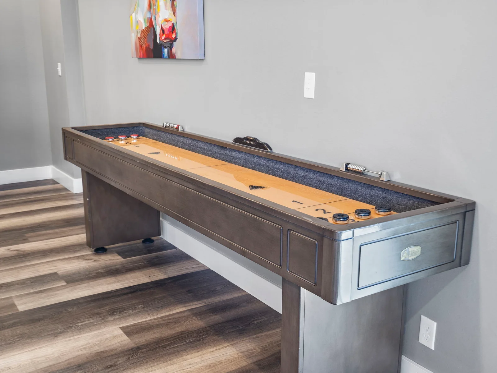 Lower level shuffleboard table