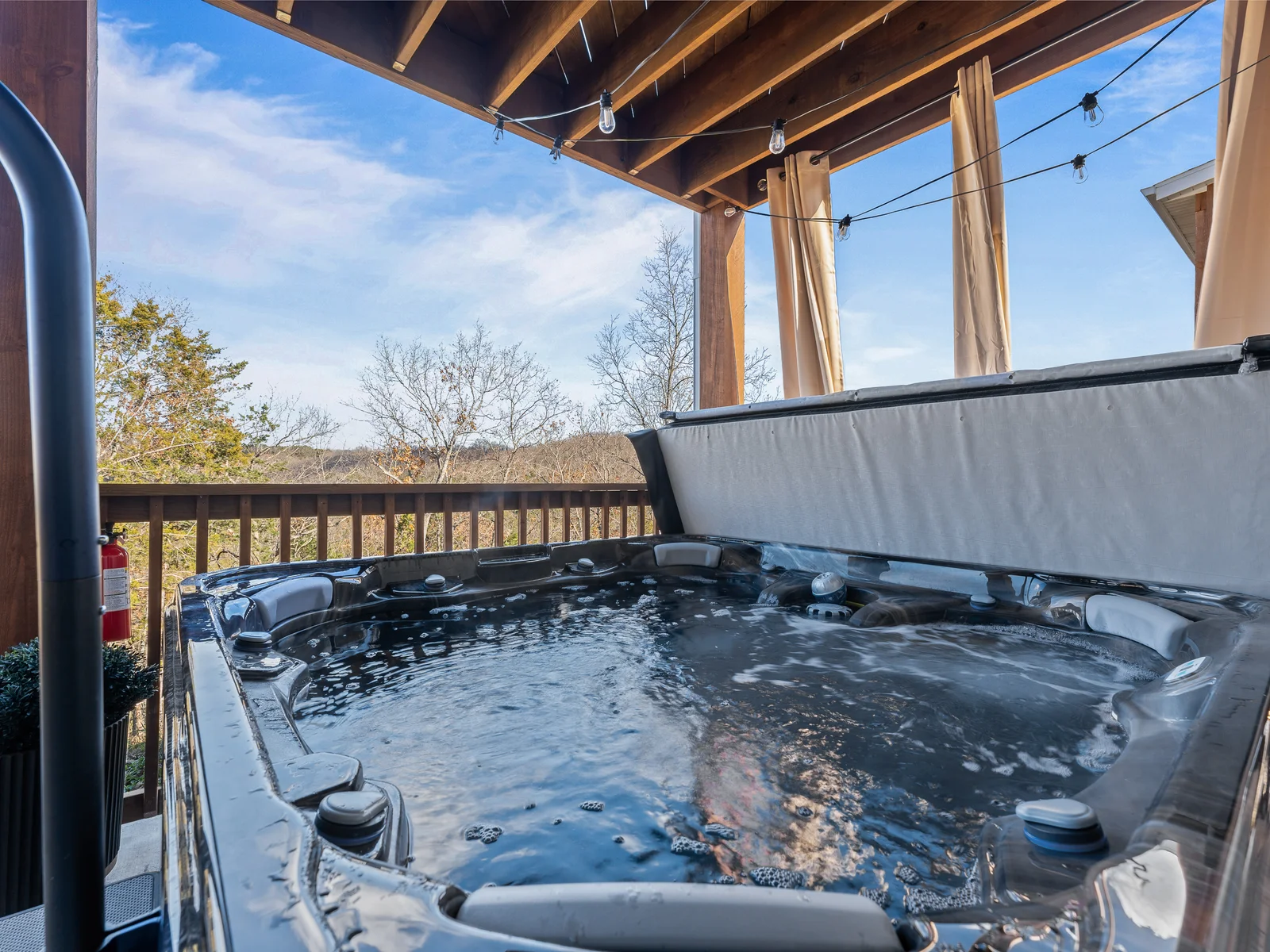 Outdoor Oasis: Unwind in the full-sized hot tub with stunning views and twinkling string lights!