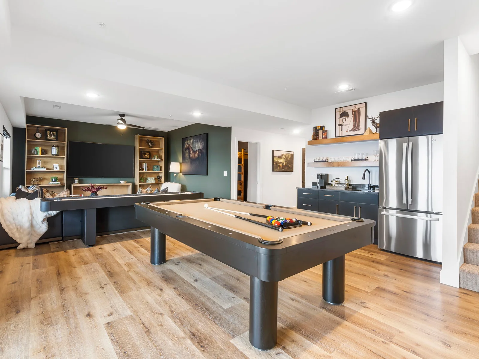 Lower level living area with pool table, shuffleboard, wetbar with fridge, and PS4