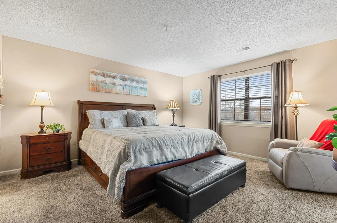 Guest bedroom with queen bed and warm lighting.