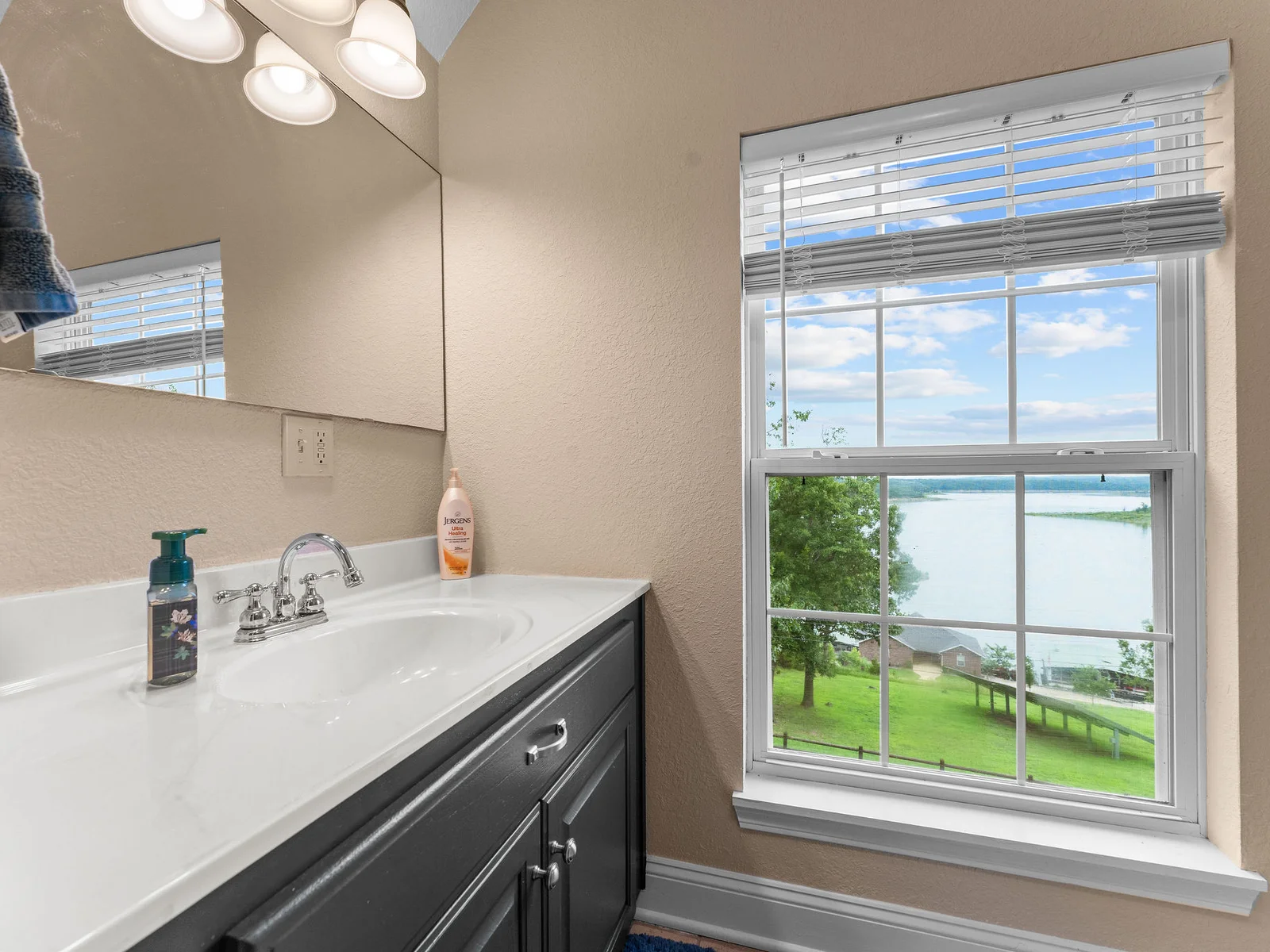 The upper-level bathroom has something you do not expect: a direct view of the lake from the window above the tub. You will look out every time.