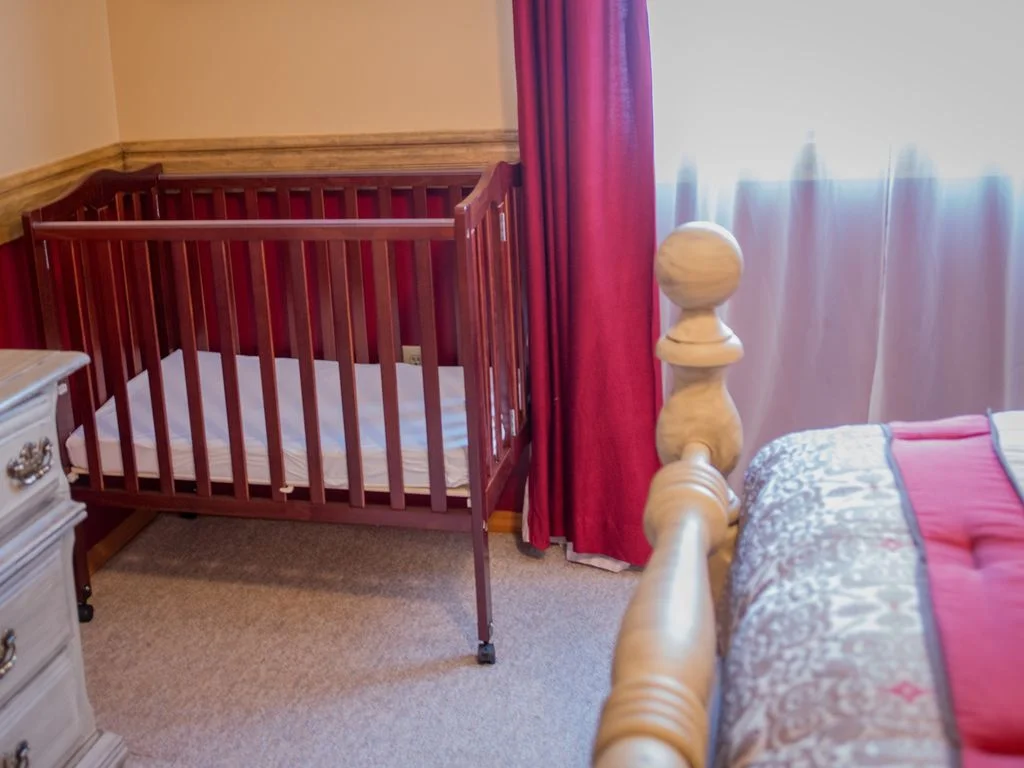 Portable crib in king bedroom #4.