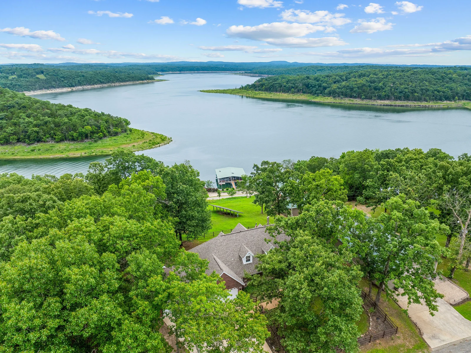 This is what you came for: Bull Shoals Lake visible through the trees behind the house, framed by Ozark hills on every side.