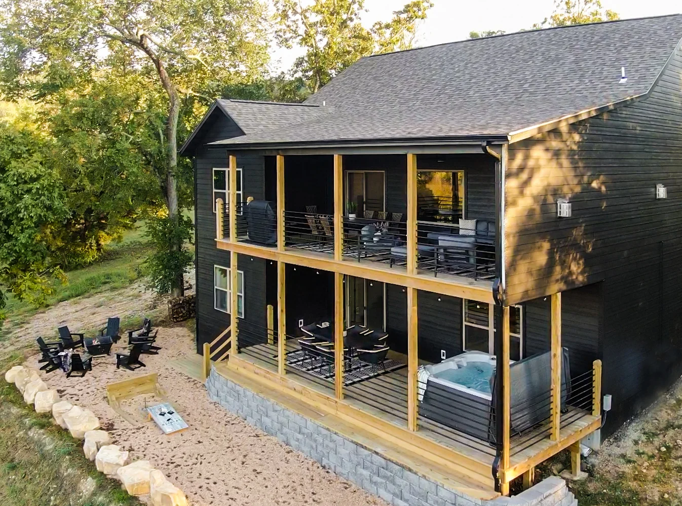 Rear elevation shows both decks, hot tub, fire pit, and more
