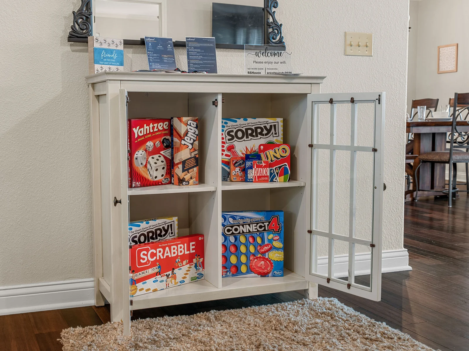 A full cabinet of classic board games — Scrabble, Yahtzee, Sorry!, Connect 4, and more — stocked and ready for a rainy afternoon or a competitive post-dinner round.