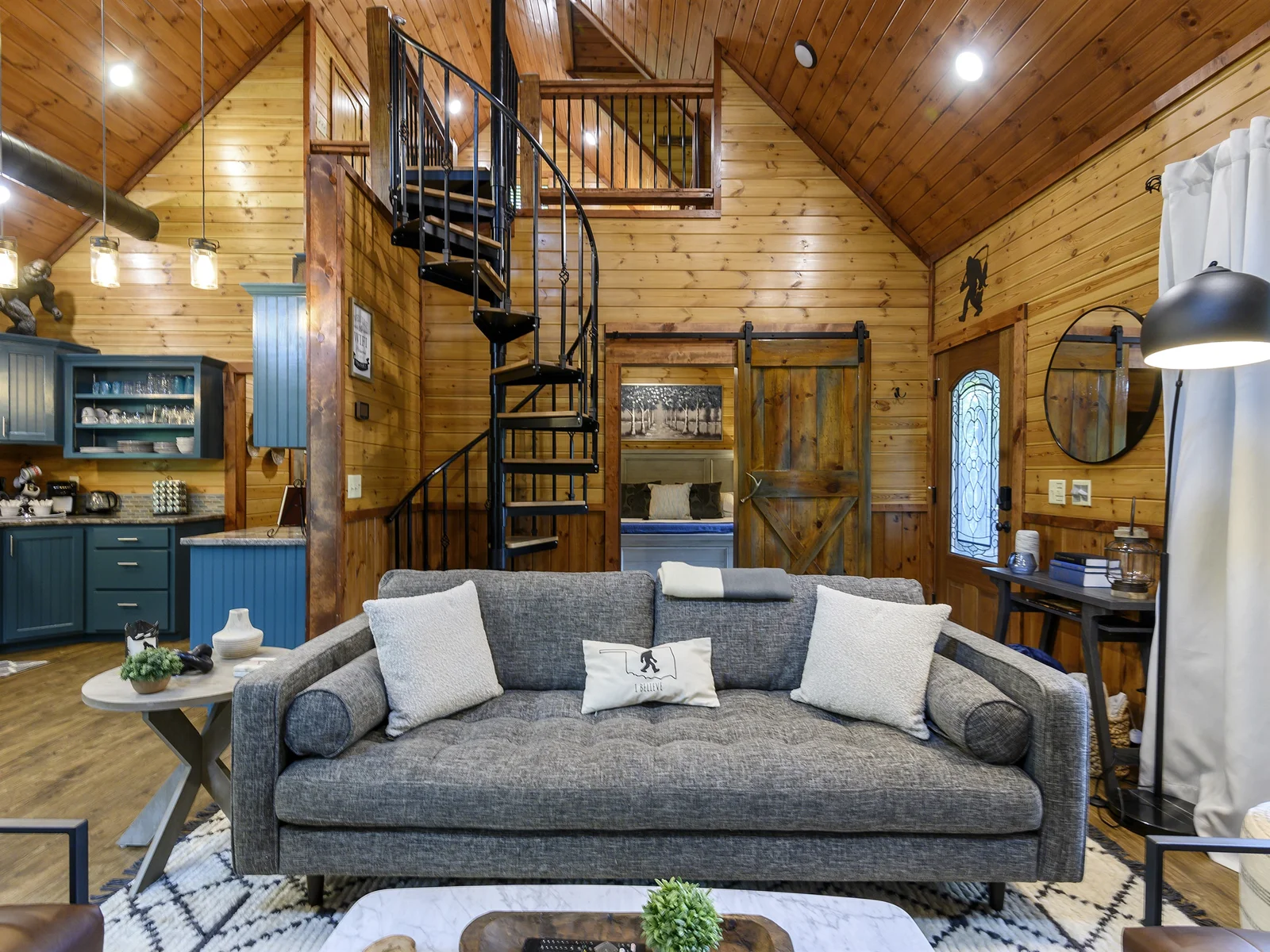 Seamless tranquility in our newly updated cabin. A living area designed for comfort, featuring a plush sofa that beckons relaxation. Peek into the serene bedroom, where modern charm meets rustic elegance. A true retreat!