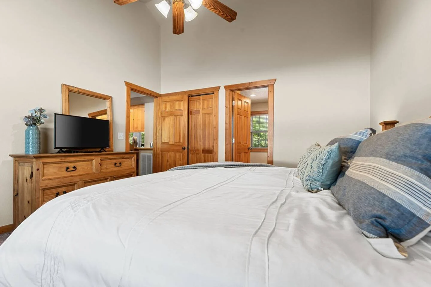 Master bedroom with king bed, smart tv, dresser and attached master bath