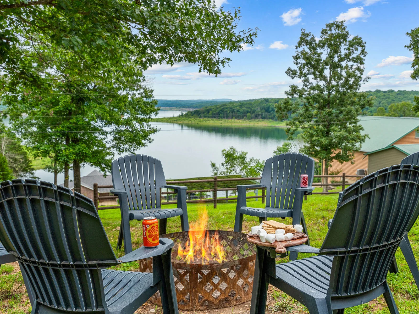S'mores board laid out, fire going, lake stretching to the horizon behind the Adirondacks — this fire pit has one of the best views of Bull Shoals Lake you will find anywhere.
