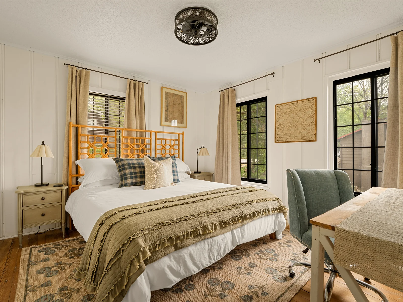 Primary bedroom with king bed and large windows.
