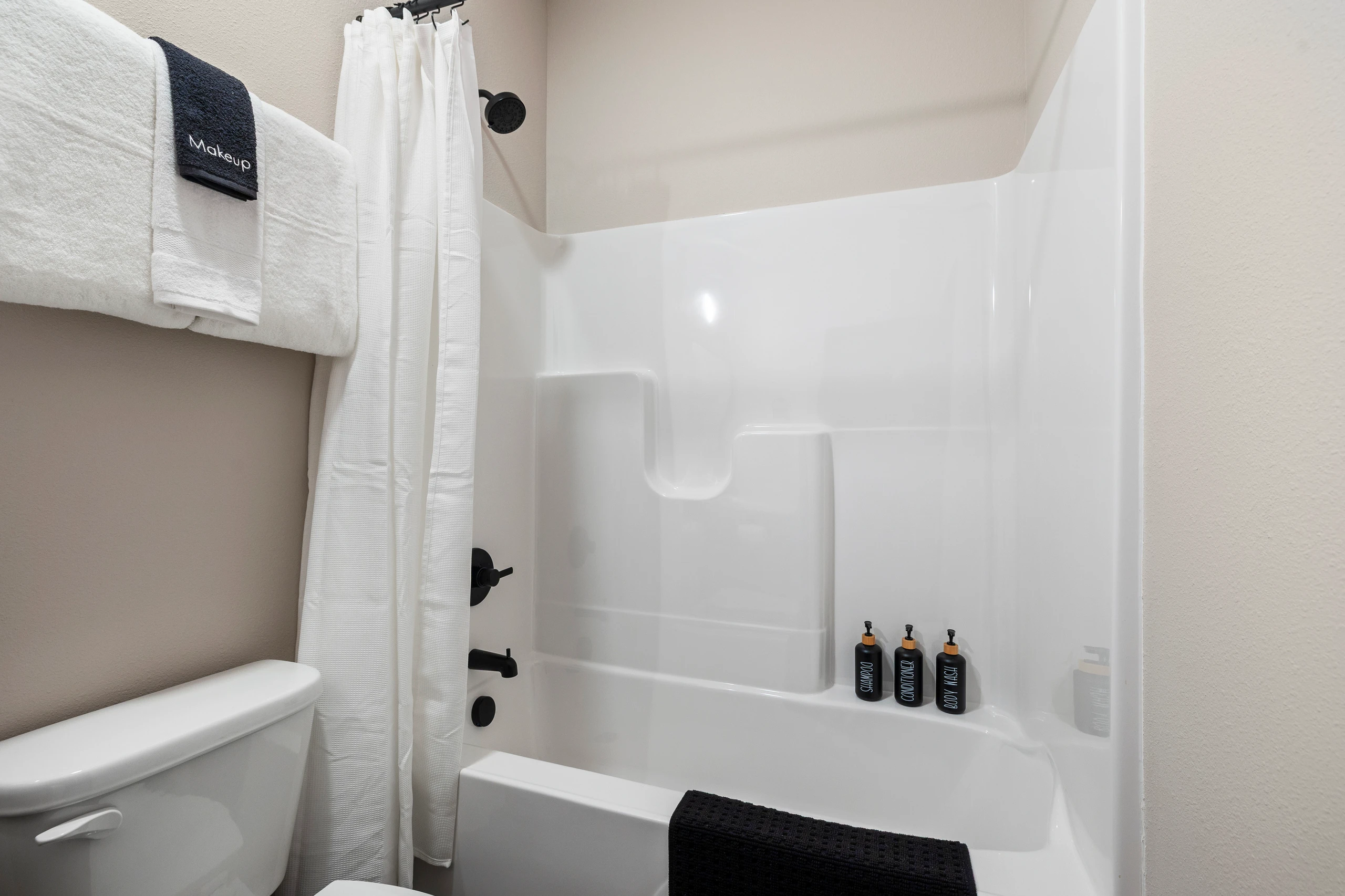 Walk-in shower, wood vanity, and a lit mirror in the ensuite.
