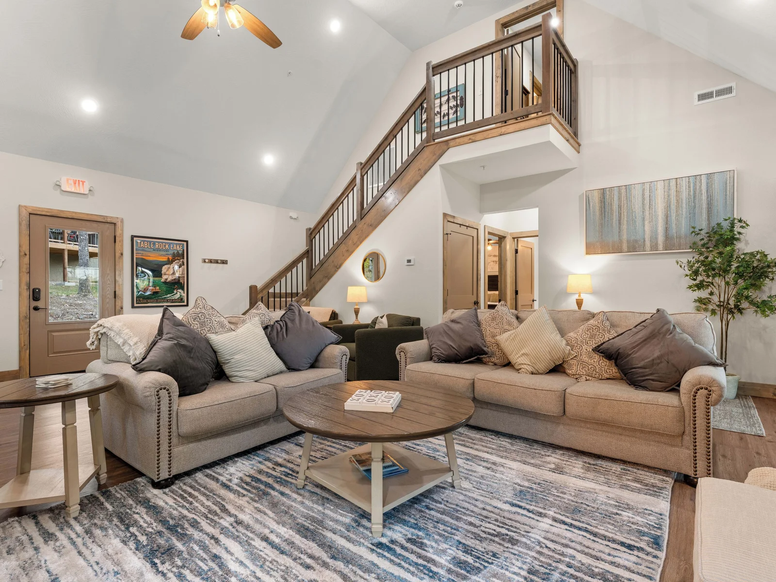 Spacious feel with high vaulted ceilings and view of upstairs landing.