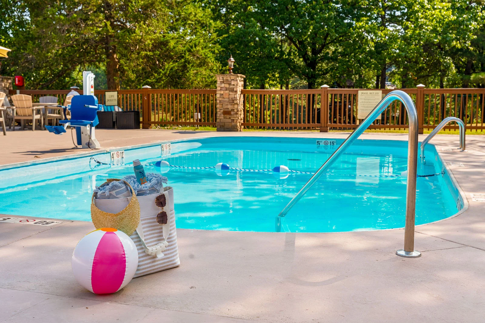 Shared neighborhood pool with lounge chairs and a pool lift. Pack the sunscreen and don't forget the beach ball!