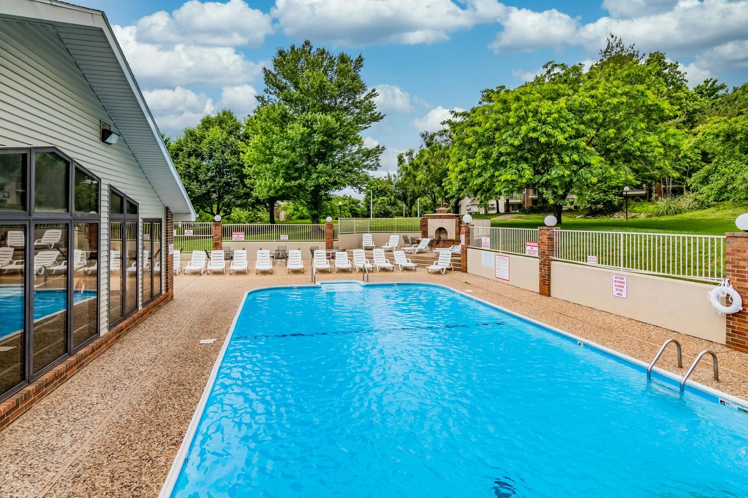 Outdoor pool and lounge area surrounded by Ozark greenery, open seasonally.