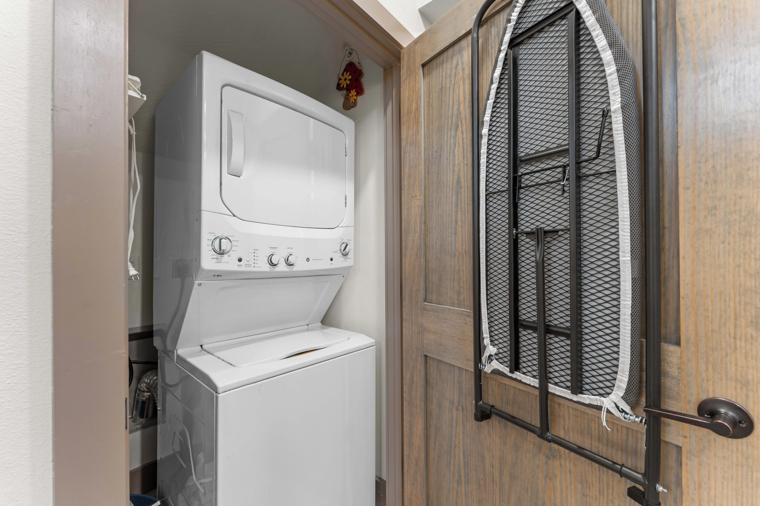 Downstairs laundry closet next to kitchen. Washer/dryer, iron board and iron. Closet also has vacuum and step stool.
