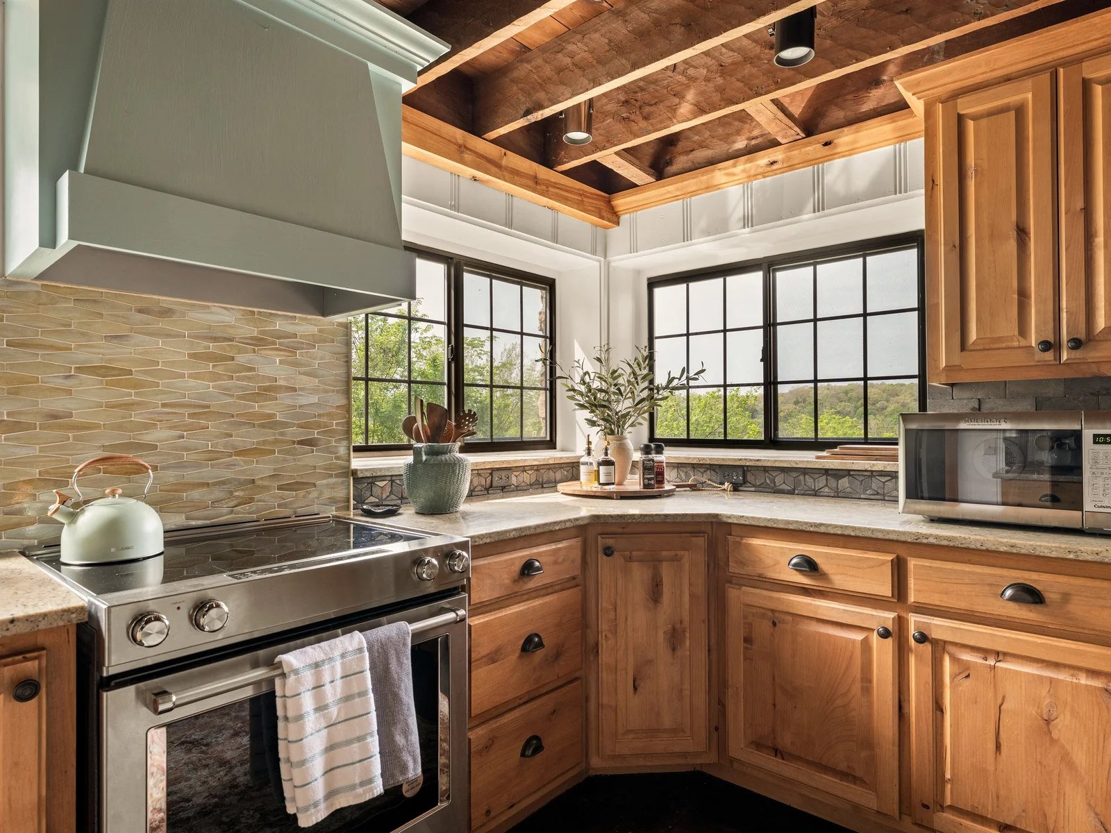 Cook with a view in this light-filled kitchen, featuring warm wood cabinetry and scenic windows.