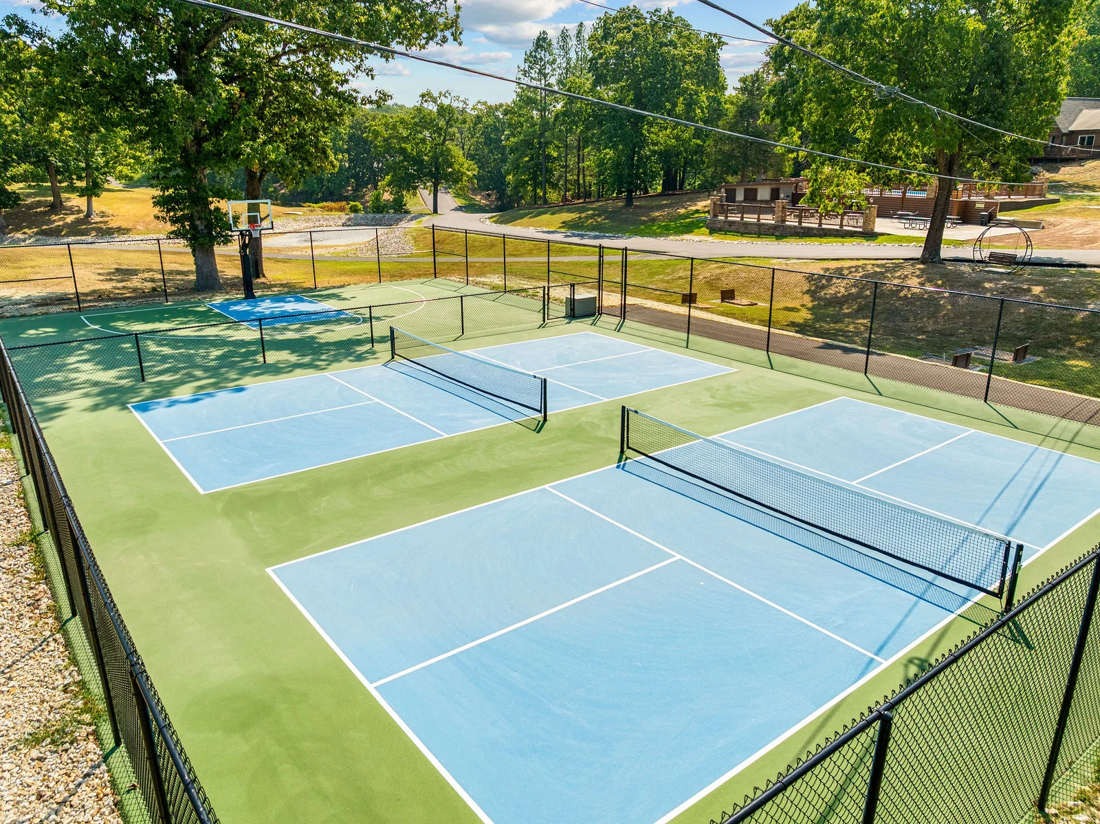 Shared pickleball courts with a basketball court beyond. Pick a team and settle the family rivalry.