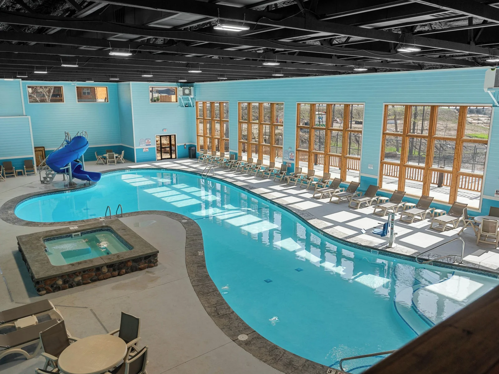 Indoor pool with view of slide and hot tub. In the distance you can see the cabin!